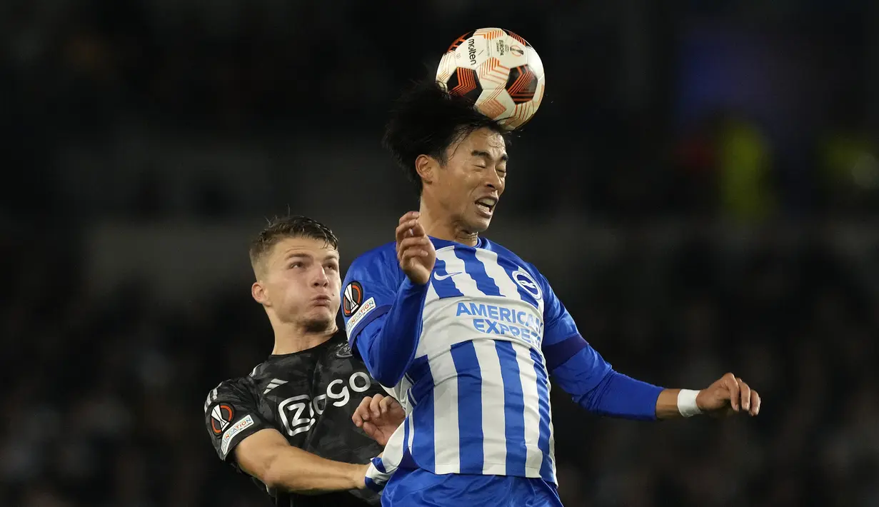 Pemain Brighton, Kaoru Mitoma (kanan) berduel udara dengan pemain Ajax Amsterdam, Steven Berghuis pada laga Grup B Liga Europa 2023/2024 di American Express Community Stadium, Brighton, Inggris, Jumat (27/10/2023) dini hari WIB. (AP Photo/Frank Augstein)