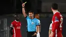 Wasit Felix Brych memberi kartu kuning kepada striker Liverpool, Sadio Mane (kiri) saat melawan Real Madrid dalam laga leg pertama babak perempatfinal Liga Champions 2020/2021 di Alfredo di Stefano Stadium, Selasa (6/4/2021). Liverpool kalah 1-3 dari Real Madrid. (AFP/Gabriel Bouys)