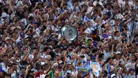 Para penggemar membawa drum bergambar wajah Lionel Messi #10 dari Argentina selama pertandingan babak 16 besar Piala Dunia 2026 antara Argentina dan Mesir di Stadion Atlanta pada 8 Juli 2026 di Atlanta, Georgia. (Justin Setterfield/Getty Images via AFP)