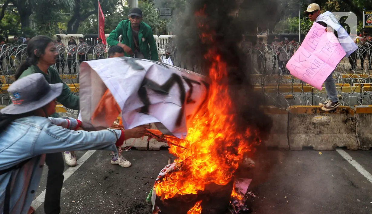 Sejumlah elemen mahasiswa menggelar demo dengan membakar ban bekas di kawasan Patung Kuda, Jakarta Pusat, Selasa (13/9/2022). Demo tersebut untuk menolak kebijakan pemerintah menaikkan harga bahan bakar minyak (BBM). (Liputan6.com/Johan Tallo)