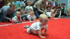 Seorang bayi mengikuti lomba merangkak untuk memperingati Hari Anak Internasional di Vilnius, Lithuania, Kamis (1/6). Orang tua memberikan iming-iming benda kesukaan buah hatinya saat mengikuti lomba. (Petras Malukas/AFP)