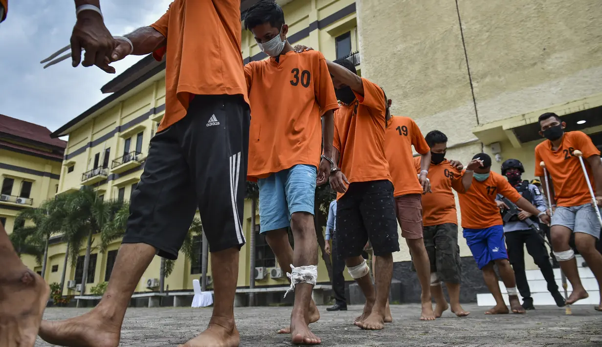 Tersangka penyelundup narkoba dihadirkan saat rilis di Mapolda Aceh di Banda Aceh, Selasa (3/11/2020). Kabid Humas Polda Aceh Kombes Pol Ery Apriyono mengatakan selain menyita puluhan kilogram sabu-sabu dan ekstasi, polisi juga menangkap sembilan tersangka. (AFP/Chaideer Mahyuddin)