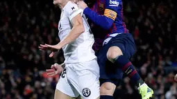Pemain Barcelona, Lionel Messi (kanan) berebut bola udara dengan pemain Valencia Carlos Soler saat bertanding dalam lanjutan Liga Spanyol di Camp Nou, Spanyol, Minggu (3/2). Dua gol Messi membuat pertandingan berakhir 2-2. (AP Photo/Manu Fernandez)