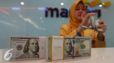 Petugas tengah menata mata uang dolar di Jakarta, Rabu (13/9). Dolar AS mulai menguat terhadap rupiah. (Liputan6.com/Angga Yuniar)