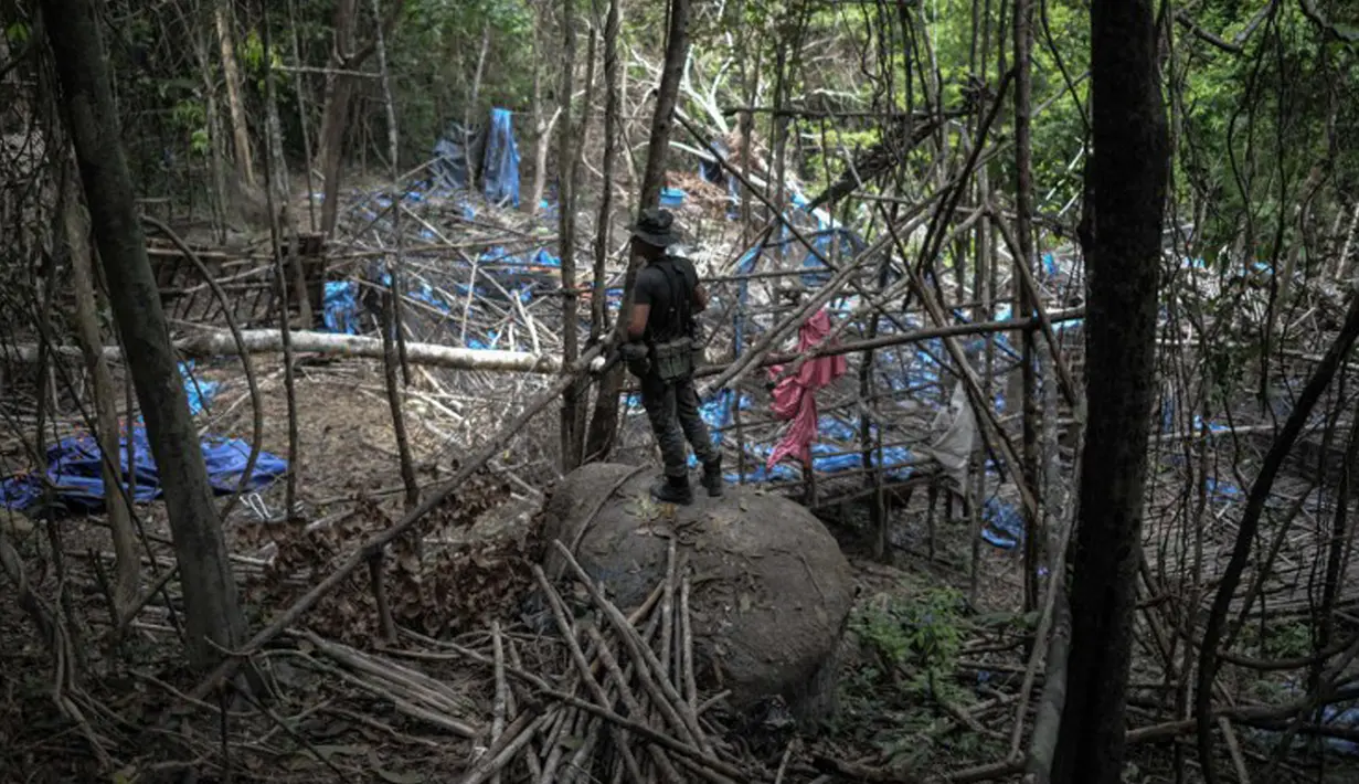 Petugas berjaga di sebuah kamp dilokasi kuburan massal di Wang Burma, dekat perbatasan Malaysia-Thailand, (26/5/2015). 139 kuburan massal yang berisi kerangka orang ditemukan.  (AFP PHOTO/MOHD RASFAN)