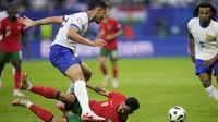 Gelandang Portugal Bruno Fernandez terjungkal saat berebut bola dengan bek Prancis William Saliba pada laga perempat final Euro 2024 (AP)