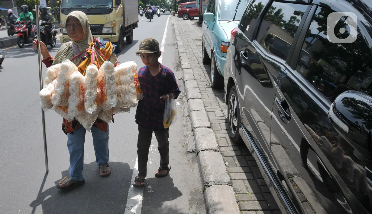 <p>Penyandang tunanetra Ibu Adel (48) berjalan bersama anak bungsunya menyusuri jalan raya Ciputat, Tangerang Selatan, Selasa (26/04/20222). Warga Pondok Cabe 3 ini setiap harinya menyusuri jalan hingga sekitar 10 km menjajakan kerupuk Bangka yang dijualnya Rp 25 ribu/bungkus. Sudah beberapa bulan terakhir ini ia mengaku pendapatannya merosot drastis hanya sekitar Rp 50 ribu/ hari yang digunakan untuk mencukupi kebutuhan sehari-hari. (merdeka.com/Arie Basuki)</p>