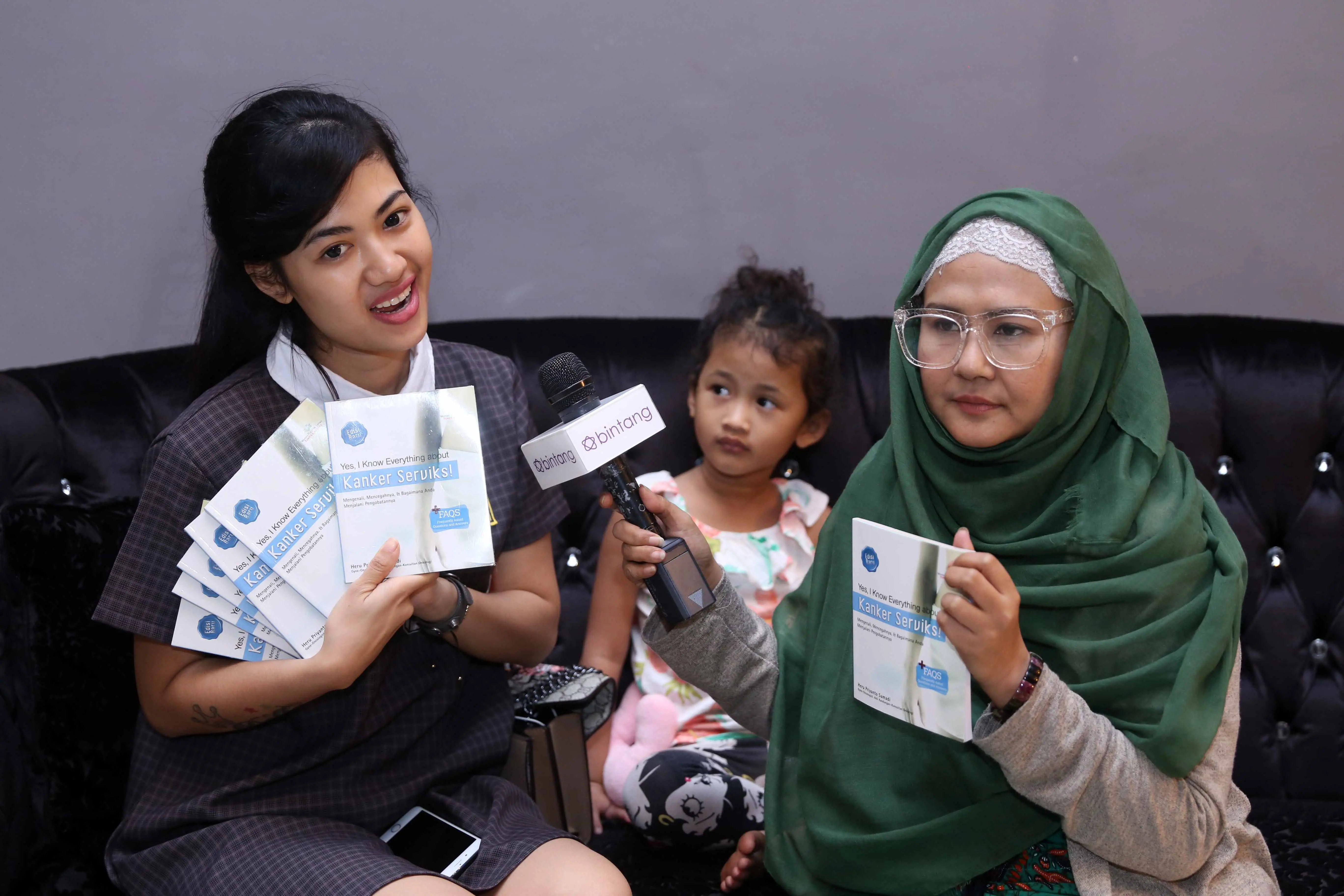 Ria menyerahkan sejumlah buku tentang kanker yang akan dibagikan bagi penggemar Julia Perez. (Nurwahyunan/bintang.com)