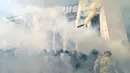Demonstran menyerang polisi dengan bom asap dan granat gas air mata di depan gedung Parlemen Ukraina , Senin (31/8). Satu petugas tewas dan 90 lainnya terluka dalam aksi yang menentang perubahan UU dasar mengenai desentralisasi. (AFP PHOTO/Genya SAVILOV)