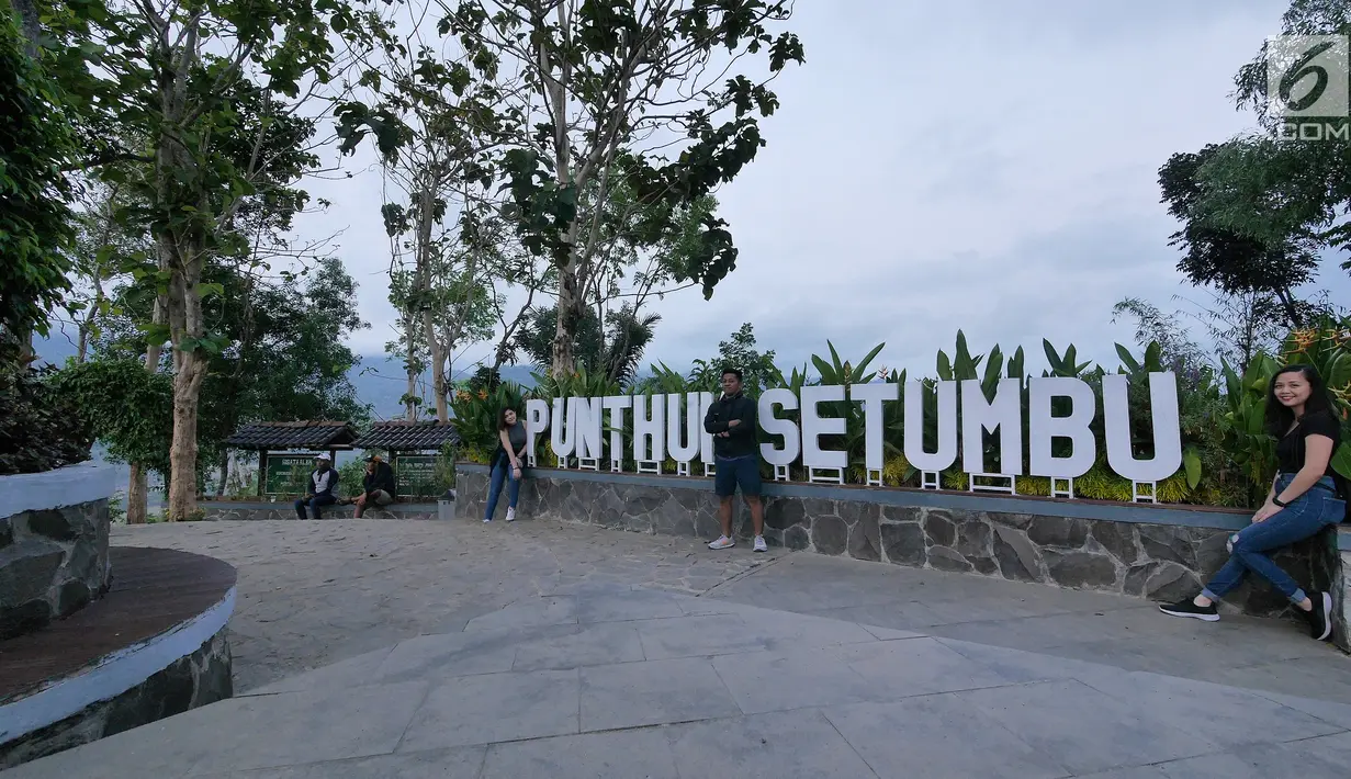 Wisatawan berfoto di tulisan Punthuk Setumbu, Magelang, Jawa Tengah, Jumat (19/10). Bukit Punthuk Setumbu merupakan salah satu spot terbaik untuk menyaksikan sunrise dengan latar Gunung Merapi Merbabu. (Liputan6.com/Herman Zakharia)