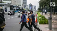 Pejalan kaki menyeberang jalan di kawasan Sudirman, Jakarta Pusat, Rabu (6/1/2021). Pemerintah memberlakukan kebijakan pembatasan sosial berskala besar (PSBB) di wilayah Jawa dan Bali mulai 11 hingga 25 Januari 2021 menyusul lonjakan kasus Covid-19 di sejumlah daerah. (Liputan6.com/Faizal Fanani)