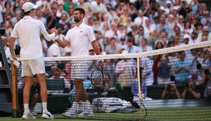 Petenis Italia, Jannik Sinner (kiri), berjabat tangan dengan petenis Serbia, Novak Djokovic, setelah memenangkan pertandingan semifinal tunggal putra mereka pada hari&nbsp;ke-12 Kejuaraan Wimbledon 2025 di All England Lawn Tennis and Croquet Club di Wimbledon, London barat daya, pada 11 Juli 2025. (HENRY NICHOLLS/AFP)