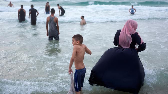 Muslim Palestina bermain dan berenang saat menghabiskan hari libur Lebaran di pantai Tel Aviv, Israel, 6 Juni 2019. Selama Idul Fitri, pemerintah Israel mengizinkan warga Palestina mengunjungi negaranya untuk menandai berakhirnya ibadah puasa Ramadan. (AP Photo/Oded Balilty)