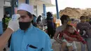 Petugas memeriksa suhu tubuh warga yang ingin menuju wilayah Sukabumi saat sterilisasi kendaraan di Terminal Cicurug, Sukabumi, Jawa Barat, Minggu (12/4/2020). Proses sterilisasi ini dilakukan untuk mencegah penyebaran virus corona COVID-19. (merdeka.com/Arie Basuki)