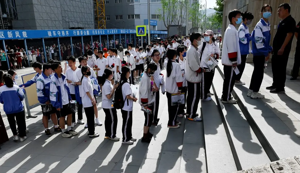 <p>Siswa berbaris untuk masuk sekolah pada hari pertama ujian masuk perguruan tinggi nasional yang dikenal sebagai gaokao di Beijing, China, Rabu (7/6/2023). (WANG Zhao/AFP)</p>