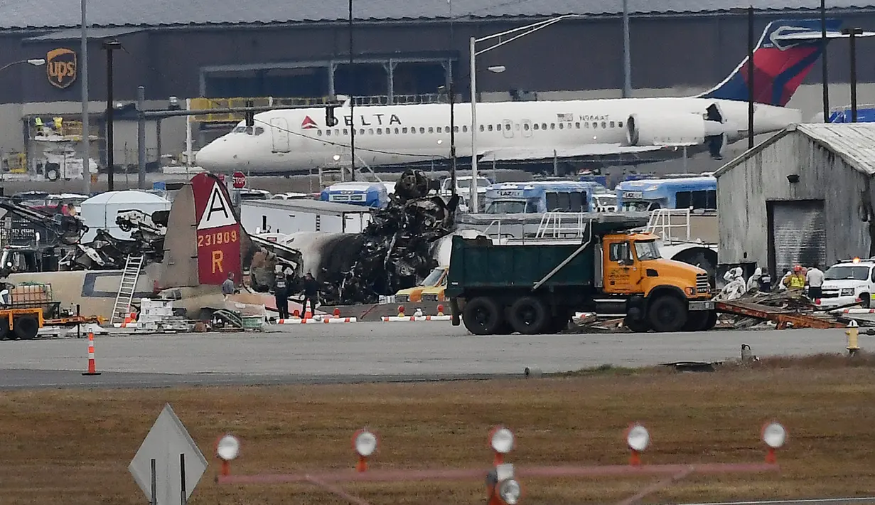 Sebuah pesawat lepas landas di dekat bangkai pesawat pengebom era Perang Dunia II yang jatuh di Bandara Internasional Bradley, Connecticut, Rabu (2/10/2019). Pesawat pengebom itu pernah dikerahkan Angkatan Udara AS untuk melawan Jerman dan Jepang saat Perang Dunia II. (AP Photo/Jessica Hill)