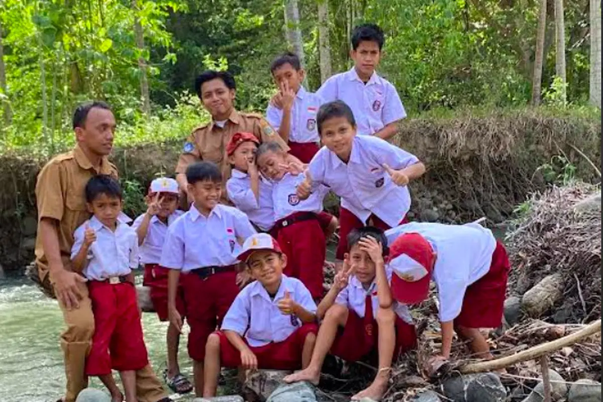 Pak Guru Najib Nadir bersama sejumlah murid-muridnya di tepi sungai. (Dokomen Pribadi Najid Nadir)