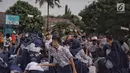 Para murid saling berebut hujan uang di lapangan SMP Angkasa Halim Perdana Kusuma, Jakarta, Kamis (7/6). Hujan uang ini dalam rangka pre-launching buku milik motivator bisnis Tung Desem Waringin berjudul "LIFE REVOLUTION." (Liputan6.com/Faizal Fanani)
