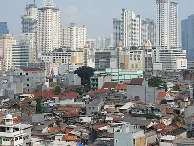 Lansekap pemukiman penduduk berlatar gedung bertingkat terlihat dari Tanah Abang, Jakarta, Selasa (21/5). Laporan Oxford Economics berjudul Global Cities 2018 menyebut Jakarta akan jadi kota dengan jumlah penduduk terbesar di dunia pada 2035, yakni 38 juta jiwa. (Liputan6.com/Immanuel Antonius)