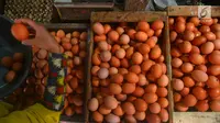 Penjual menunjukkan telur dagangannya di Pasar Minggu, Jakarta, Rabu (24/7). Harga telur ayam mengalami penurunan di angka Rp 26 ribu per kilo. (Merdeka.com/Imam Buhori)