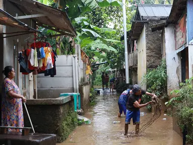 Warga membersihkan lumpur dari banjir yang menggenangi Gang Arus Dalam di Cawang, Jakarta Timur, Rabu (24/4). Banjir kiriman dari Bogor yang menggenangi kawasan tersebut menyisakan lumpur dan sampah sehingga menganggu aktivitas warga. (Liputan6.com/Immanuel Antonius)