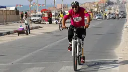 Seorang pengendara sepeda dengan kaki palsu berkompetisi dalam balapan lokal di jalan tepi pantai di Kota Gaza, Rabu (30/6/2021).  Pria dan wanita serta pembalap amputasi dari berbagai kelompok umur berpartisipasi dalam perlombaan tersebut. (AP Photo/Adel Hana)