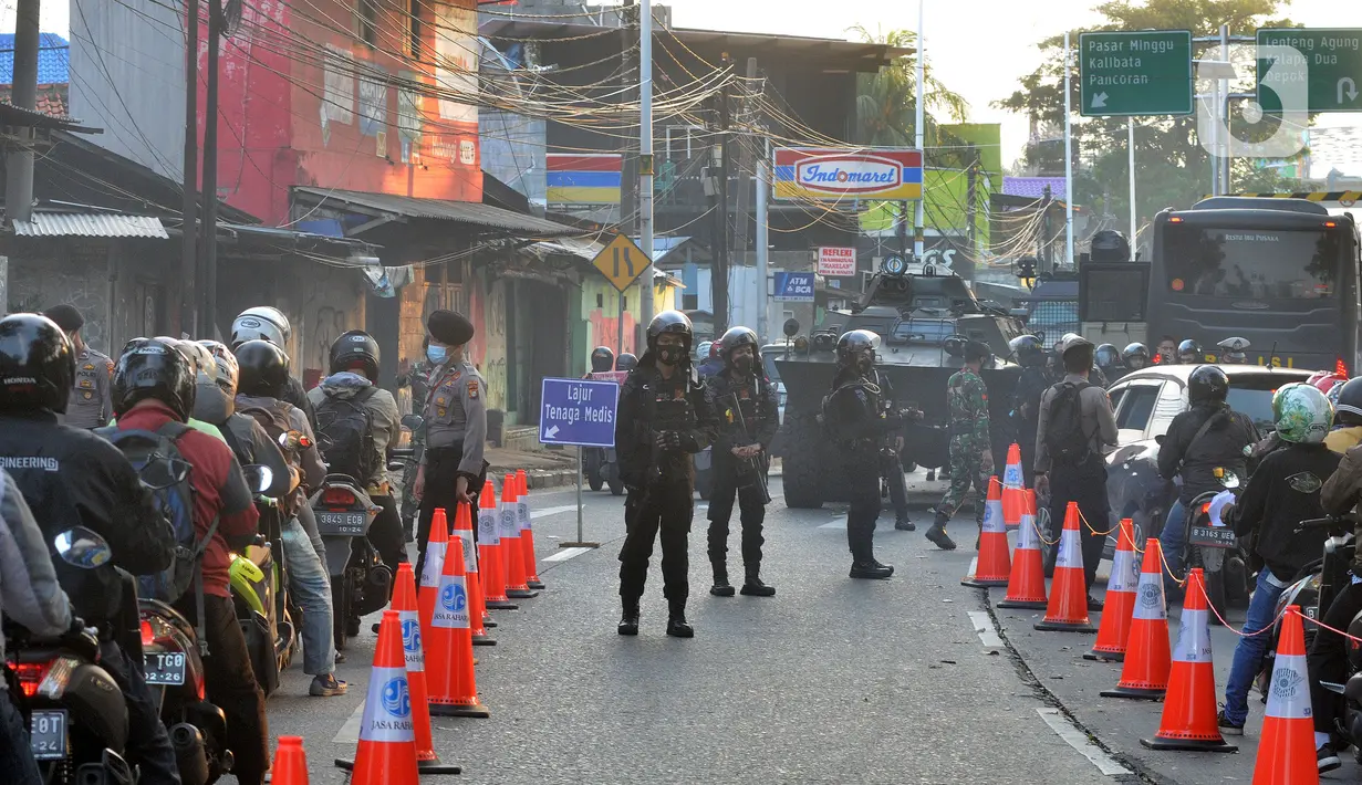 Suasana kanalisasi pos penyekatan PPKM Darurat di Jalan Raya Lenteng Agung, Jakarta, kamis (8/7/2021). Kanalisai bagi pekerja esensial dan kritikal tesebut mengurangi kemacetan arus lalu lintas dalam mengurangi mobilitas warga di masa PPKM Darurat. (merdeka.com/Arie Basuki)