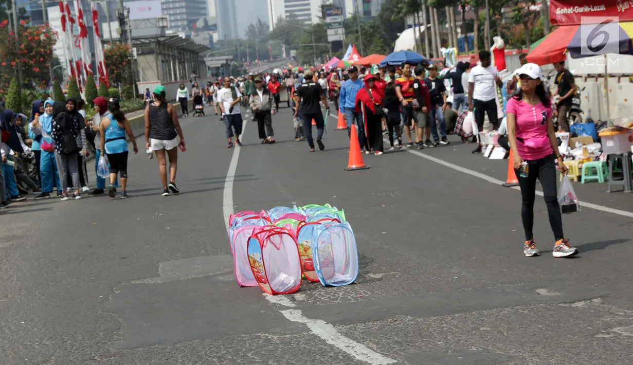 Pedagang kaki lima (PKL) menggelar dagangannya di Jalan Jenderal Sudirman saat Hari Bebas Kendaraan, Jakarta, Minggu (25/8/2019). Para PKL ini menggelar dagangannya terlalu menjorok ke tengah jalan sehingga mengganggu kenyamanan warga yang berolahraga saat CFD. (Liputan6.com/Helmi Fithriansyah)