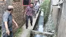 Cagub DKI Basuki Tjahaja Purnama ( Ahok ) menyusuri saluran air saat blusukan ke wilayah Cililitan, Jakarta, Rabu (28/12). Dalam blusukannya tersebut Ahok mencari tahu permasalahan banjir di Cililitan Kecil. (Liputan6.com/Yoppy Renato)