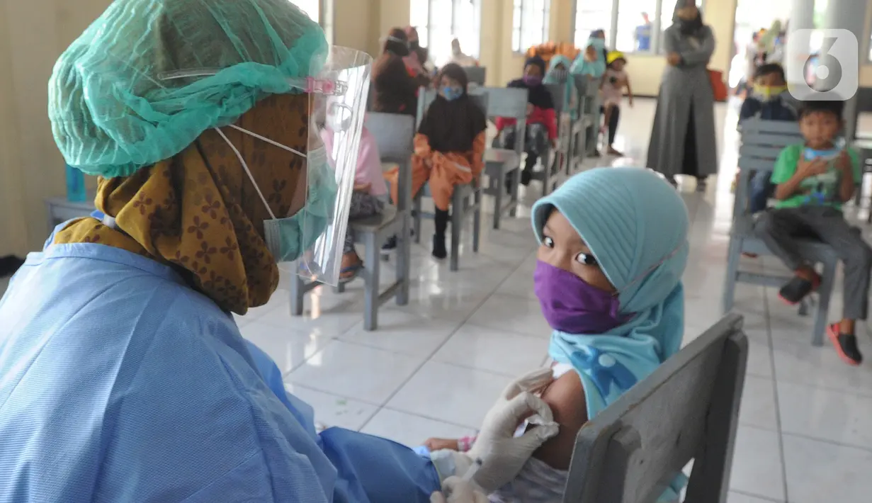 Petugas kesehatan menyuntikkan vaksin tetanus difteri ke siswa kelas 1 di SDI Al Hidayah, Cinere, Depok, Jumat (20/11/2020). Program imunisasi kepada pelajar di Kota Depok terus berjalan guna menjaga kesehatan anak dan meningkatkan imunitas tubuh di masa pandemi COVID-19. (merdeka.com/Arie Basuki)