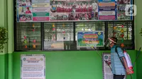 Seorang guru mendisinfeksi SDN Kenari 08, Jakarta, Selasa (6/4/2021). Skema yang akan diterapkan adalah pembelajaran tatap muka secara bergantian dengan maksimum 50 persen dari kapasitas ruangan. (Liputan6.com/Faizal Fanani)