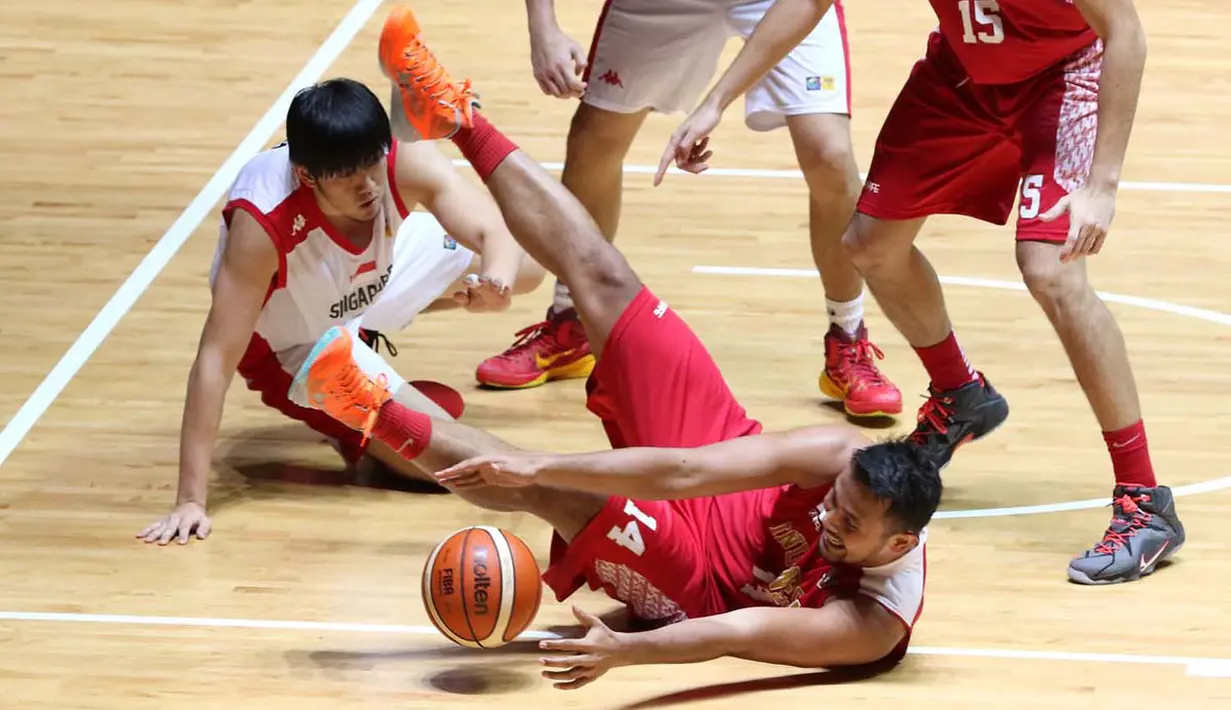 Pebasket putra Indonesia, Adhi Pratama Prasetyo Putra (14), berusaha melewati hadangan pemain Singapura dalam semi final basket SEA Games 2015. (Bola.com/Arief Bagus)