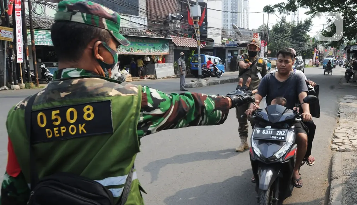 Anggota TNI-Polri menghentikan warga yang tidak mengenakan masker saat razia gabungan Kelurahan Gandul di Perempatan Gandul, Cinere, Depok, Kamis ( 29/08/2020). (merdeka.com/Arie Basuki)