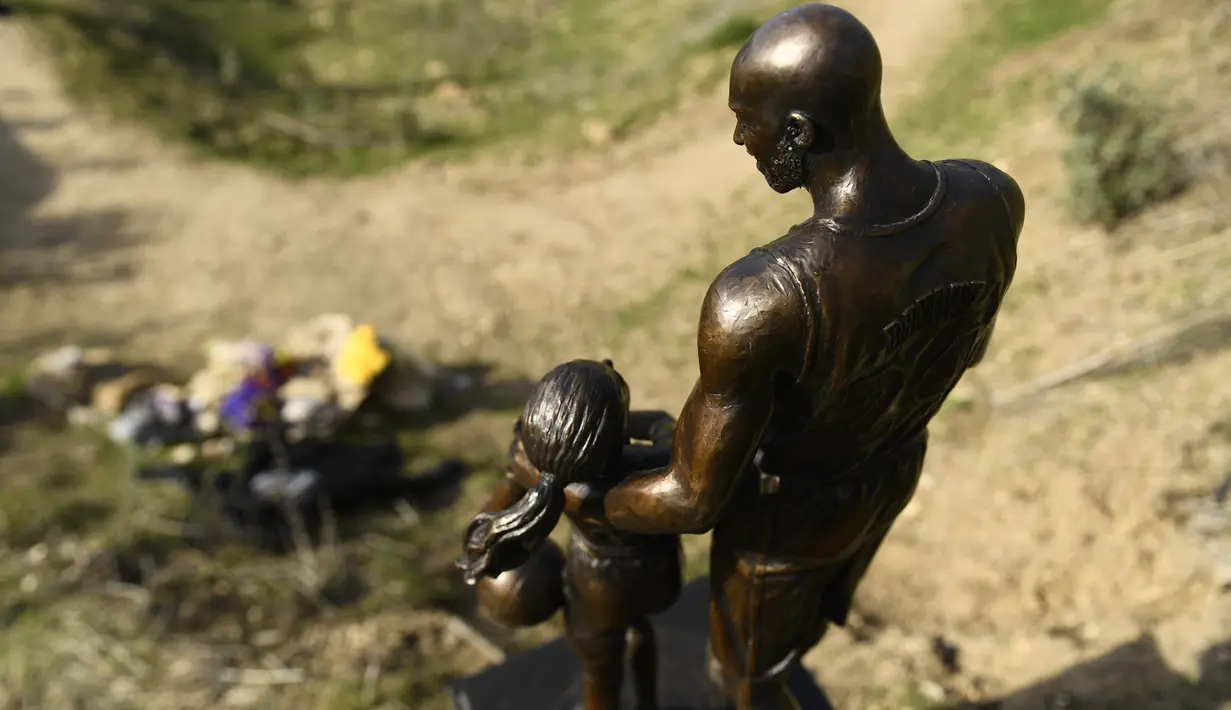 Patung untuk mengenang Kobe Bryant dan putrinya, Gianna di Calabasas, California, Rabu (26/1/2022). Patung karya seniman Dan Medina yang menggambarkan Kobe Bryant, putri Gianna Bryant, dan nama-nama mereka yang meninggal, itu ditampilkan di lokasi kecelakaan helikopter 2020. (Patrick T. FALLON / AFP