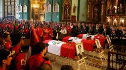 Keluarga dan rekan kerja mengahadiri upacara pemakaman di sebuah gereja di Lima, Peru (21/10). Tiga petugas pemadam kebakaran tewas saat bertugas memadamkan api di sebuah pabrik sepatu di Kota Lima. (Reuters/Guadalupe Pardo)