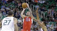 Guard LA Clippers, J.J. Redick (4) menembakkan bola menembus pertahanan Utah Jazz yang dijaga George Hill (3), dan Rudy Gobert (27) pada laga di Utah, Senin (17/10/2016) waktu setempat. (LA Times)