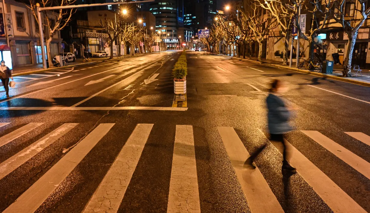Orang-orang berjalan di jalan sebelum dimulainya lockdown tahap kedua sebagai tindakan pencegahan terhadap virus corona COVID-19 di Shanghai, China, 31 Maret 2022. (Hector RETAMAL/AFP)