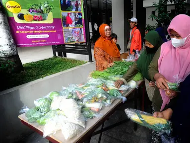 Kaum ibu mengambil gratis sayuran di Jati Padang, Pasar Minggu, Jakarta Selatan, Minggu (2/4/2023). (merdeka.com/Arie Basuki)