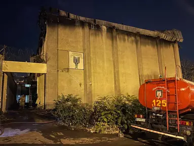 Sebuah truk pemadam kebakaran di depan penjara Evin, di barat laut ibukota Iran, Teheran, Minggu (16/10/2022). Pengadilan Iran mengatakan, kobaran api pada Sabtu (15/10) malam dimulai oleh para tahanan di sebuah gudang setelah meletup perkelahian. (Iranian Mizan News Agency via AFP)