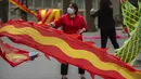 <p>Seorang wanita mengenakan masker mengibarkan bendera di taman umum di Beijing, Kamis (21/4/2022). Di daratan China, jumlah kematian meningkat menjadi lebih dari 20 dalam wabah di Shanghai yang menutup kota terbesar di negara itu. (AP Photo/Mark Schiefelbein)</p>