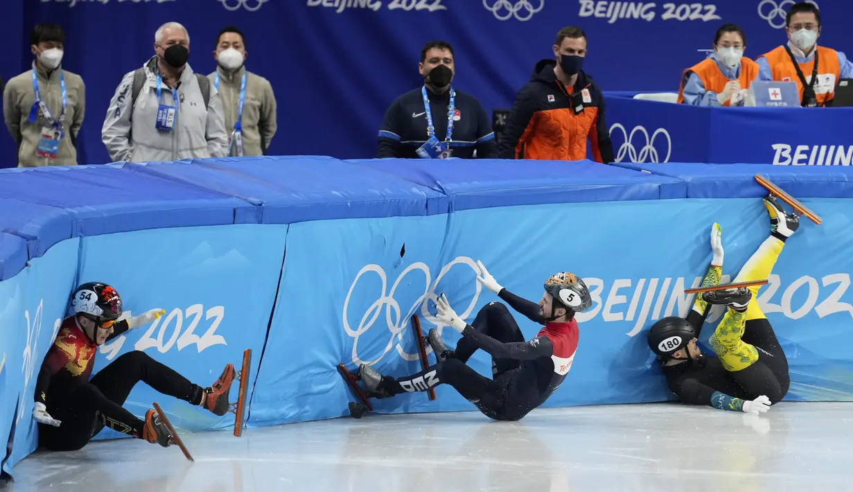 Ren Ziwei dari China (kiri), Brendan Corey dari Australia, dan Itzhak Laat dari Belanda (tengah) terjatuh di perempat final nomor 1.000 meter putra dalam kompetisi speedskating lintasan pendek di Olimpiade Musim Dingin 2022, Senin, 7 Februari 2022, di Beijing. (AP Photo/Natacha Pisarenko)