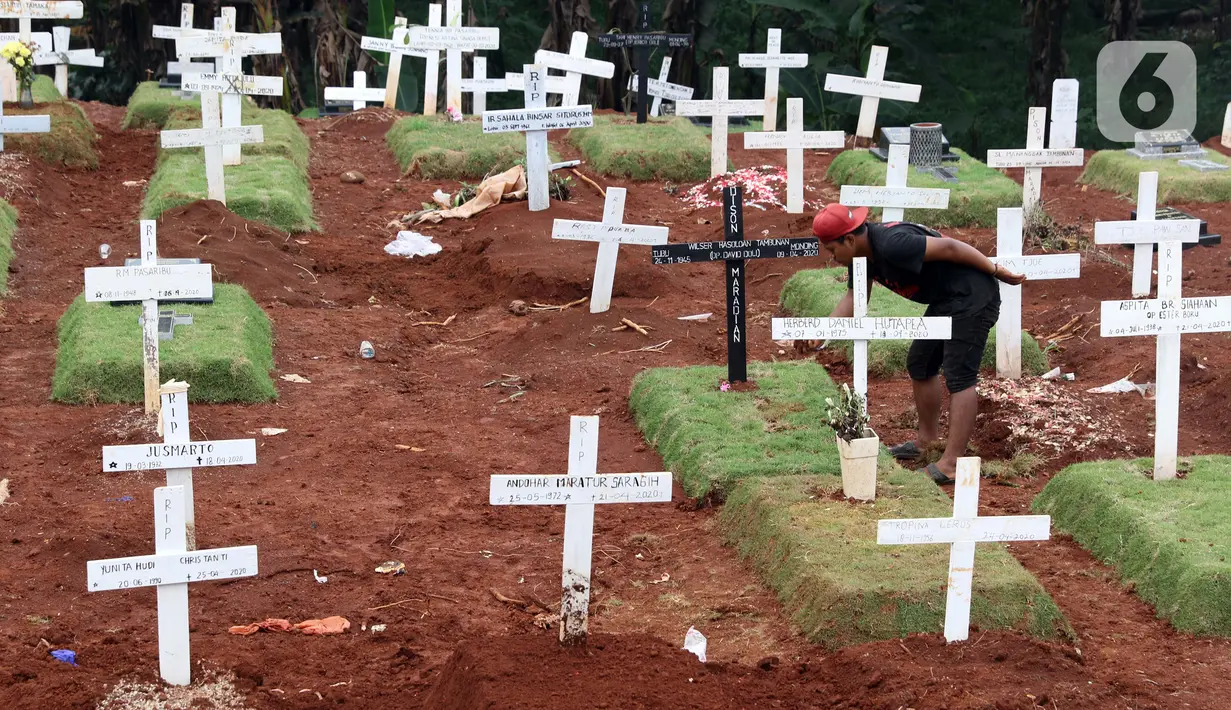 Pekerja sedang melakukan perawatan lokasi pemakaman jenazah yang diduga terinfeksi Covid-19 di TPU Pondok Ranggon, Jakarta, Kamis {30/4/2020). Sejumlah makam terlihat mulai dipasangi rumput dan batu nisan. (Liputan6.com/Helmi Fithriansyah)