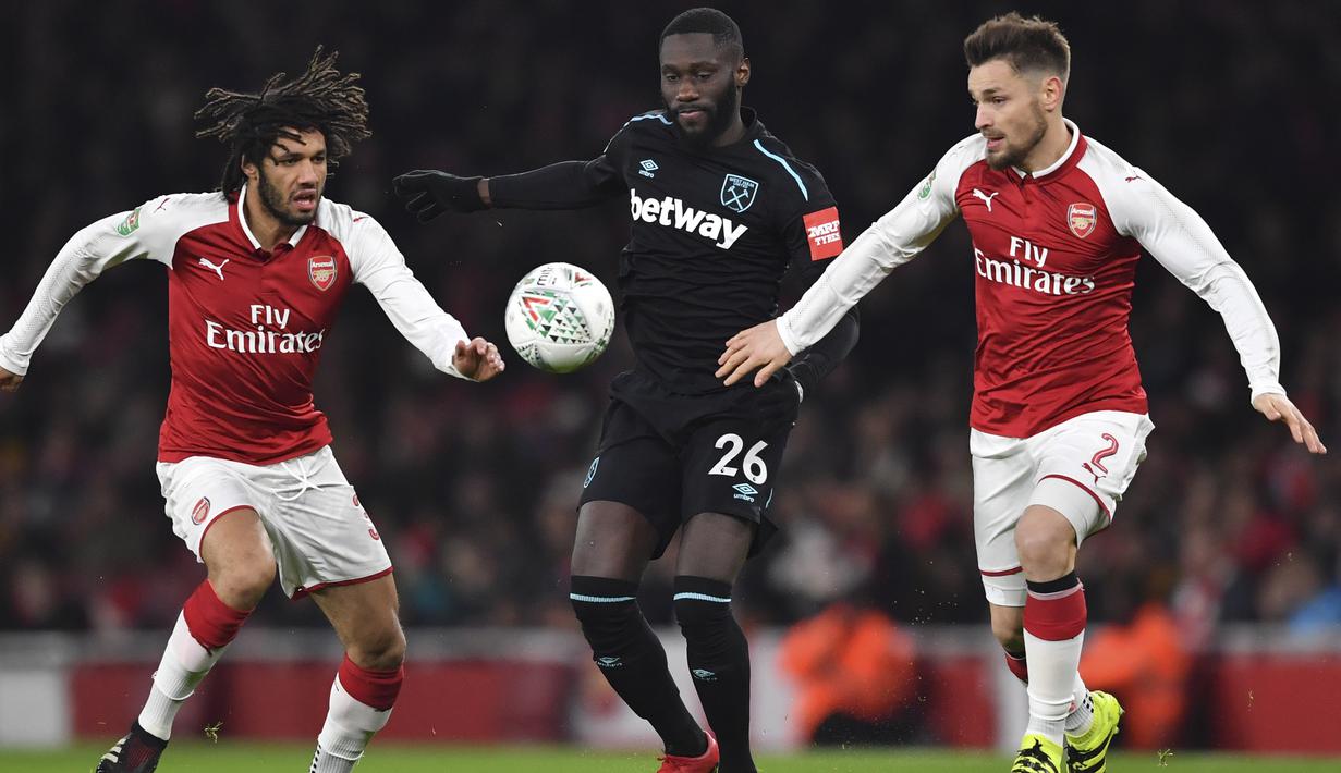Pemain West Ham United, Arthur Masuaku (tengah) berusaha melewati adangan dua pemain Arsenal pada laga Piala Liga Inggris di Emirates Stadium, London, (19/12/2017). Arsenal menang 1-0. (AFP/Ben Stansall)