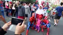 Sejumlah orang dengan kostum Spiderman berfoto bersama anak-anak di  CFD Jalan MH Thamrin, Jakarta, Minggu (6/8). Mereka mengajak warga berswafoto sambil berdonasi untuk panti asuhan. (Liputan6.com/Fery Pradolo)