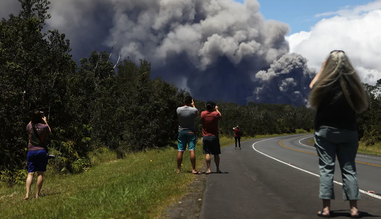 Sejumlah orang menonton dan mengambil gambar kepulan abu vulkanik dari gunung berapi Kilauea di Big Island Hawaii (15/5). Otoritas Hawaii menyatakan, awan abu mencapai ketinggian sekitar 3.000 meter hingga 3.600 meter. (Mario Tama/Getty Images/AFP)