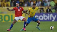 Gelandang Chile, Eduardo Vargas berebut bola dengan bek Brasil, Danilo selama pertandingan kualifikasi Piala Dunia 2022 zona CONMEBOL di stadion Maracana di Rio de Janeiro, Brasil, Jumat (25/3/2022). Brasil menang atas Chile 4-0.  (AP Photo/Silvia Izquierdo)