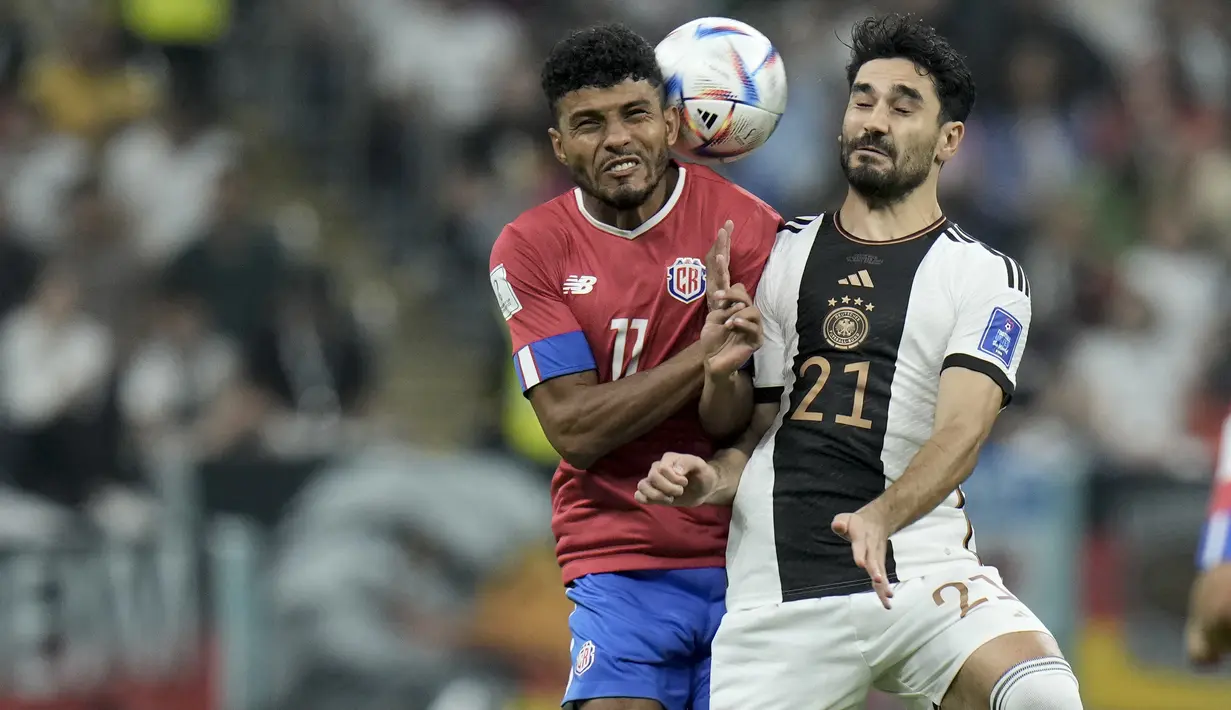 Gelandang Jerman, Ilkay Gundogan berebut bola dengan pemain Kosta Rika, Johan Venegas pada grup E Piala Dunia 2022 Qatar di di Stadion Al Bayt di Al Khor, Qatar, Jumat (2/12/2022). Jerman menang atas Kosta Rika dengan skor 4-2. (AP Photo/Hasan Ammar)