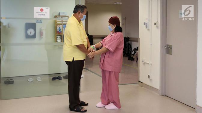 Presiden ke-6 RI Susilo Bambang Yudhoyono atau SBY (kiri) memegang tangan sang istri Ani Yudhoyono yang tengah menjalani pengobatan di National University Hospital, Singapura. (Liputan6.com/HO)