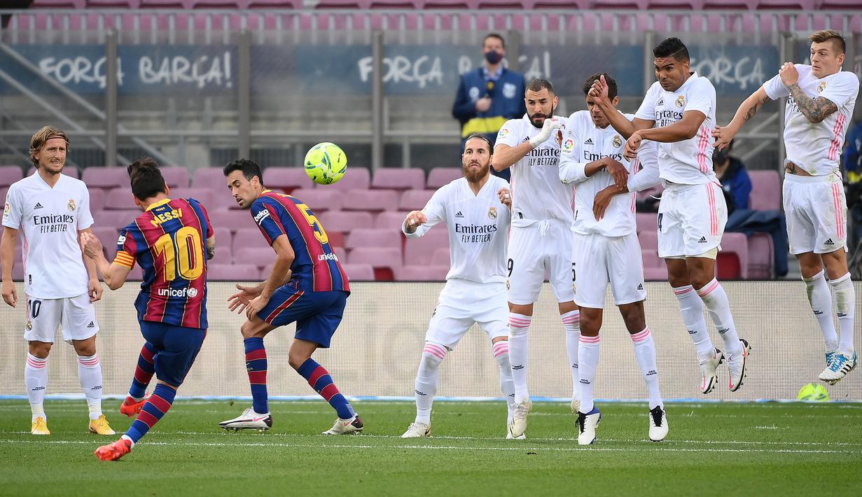 Penyerang Barccelona, Lionel Messi, saat melakukan tendangan bebas pada laga lanjutan Liga Spanyol di Camp Nou Stadion, Sabtu (24/10/2020) malam WIB. Real Madrid menang 3-1 atas Barcelona. (AFP/Lluis Gene)