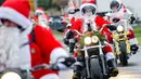 Pengendara motor besar berpakaian seperti Sinterklas menyusuri jalanan selama acara amal di Lustadt, Jerman, Kamis (6/12). Mereka mengumpulkan sumbangan untuk rumah sakit Sterntaler di Speyer, yang merawat anak-anak penderita kanker. (Uwe Anspach/dpa/AFP)